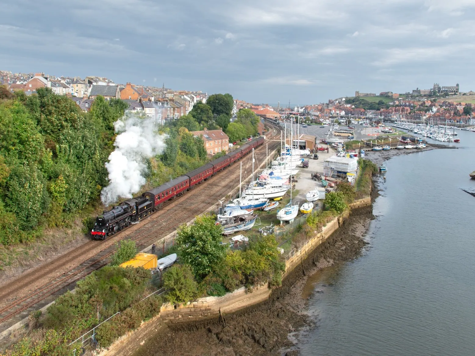 Steam Train on track by River Esk in Whitby 